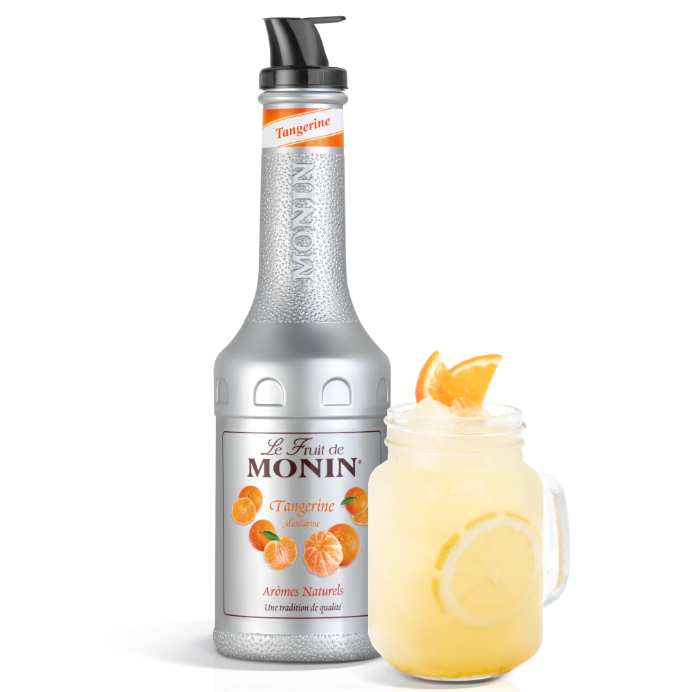 A bottle of Monin Tangerine puree stands next to a mason jar filled with an orange-tangerine drink and garnished with an orange slice, on a white background.